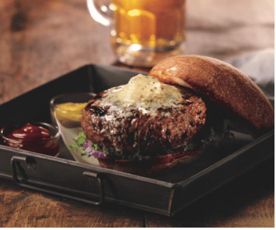 Sizzling steak with butter on top and a roll